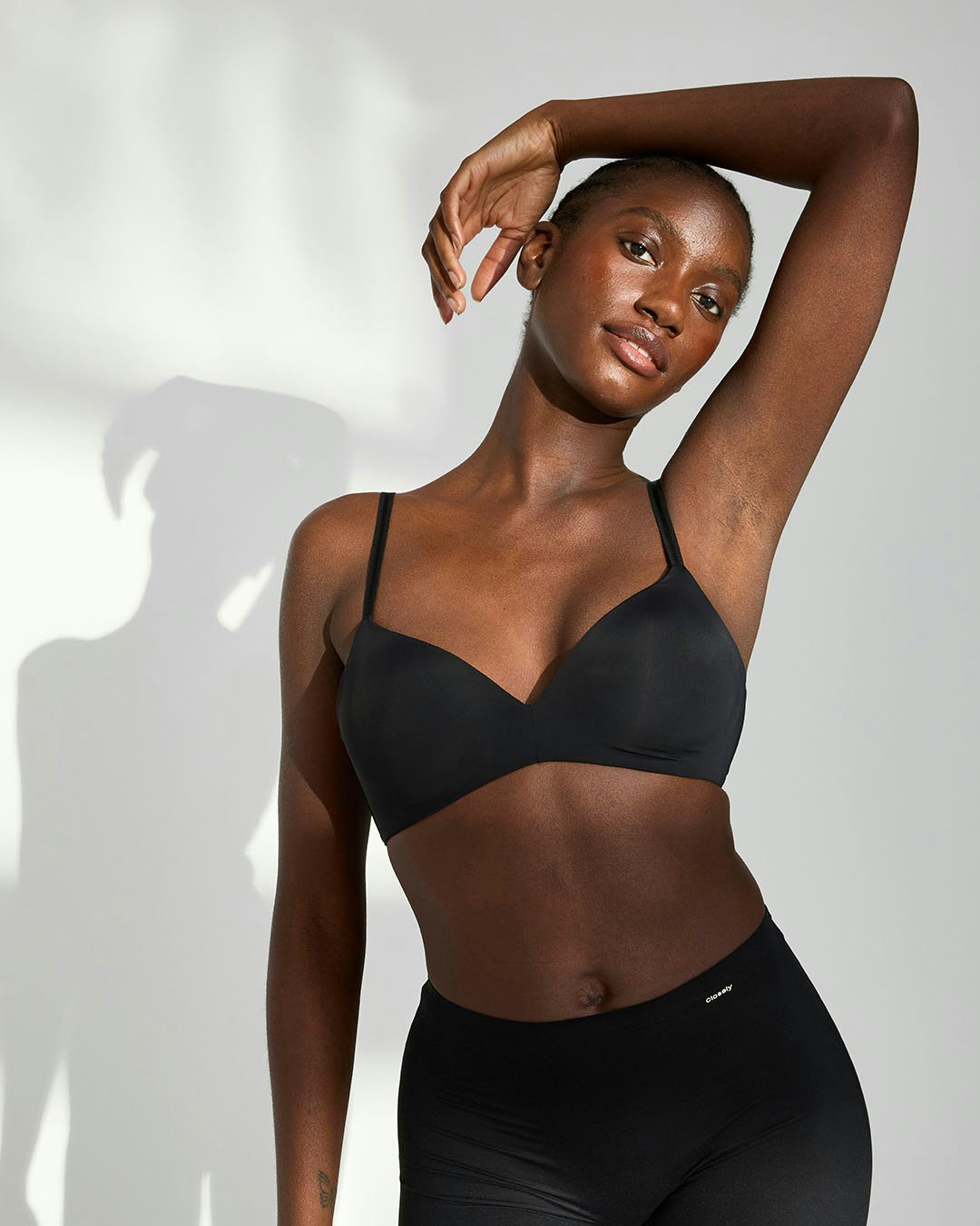 A close-up image on a woman wearing a wire free light t-shirt bra in black